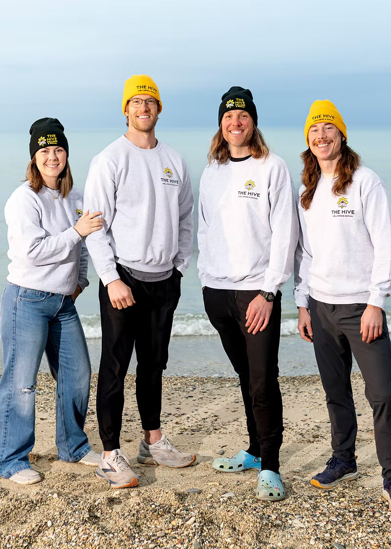 The Hive team on the Lake Michigan shoreline in branded sweatshirts